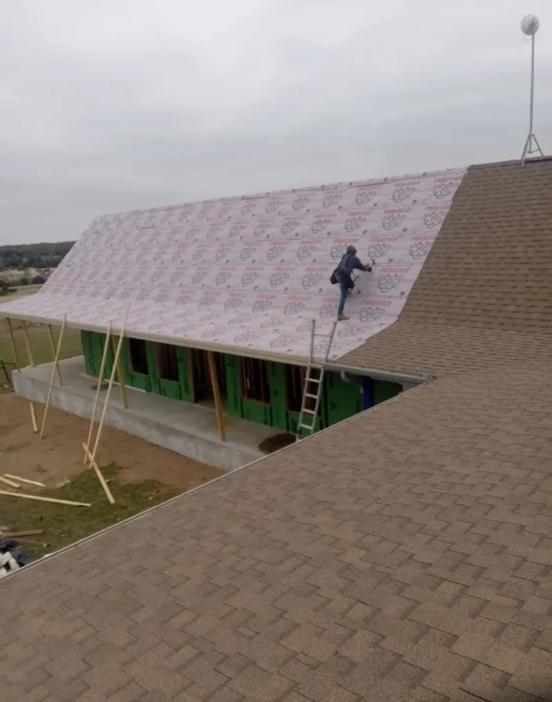 Worker preparing underlayment for a metal roof installation in Thurmont